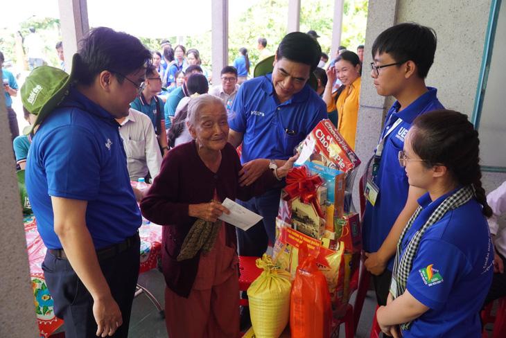 Ông Ngô Văn Luận và anh Ngô Minh Hải thăm, tặng quà cho mẹ Trần Thị Tư - Ảnh: CHÍ HẠNH