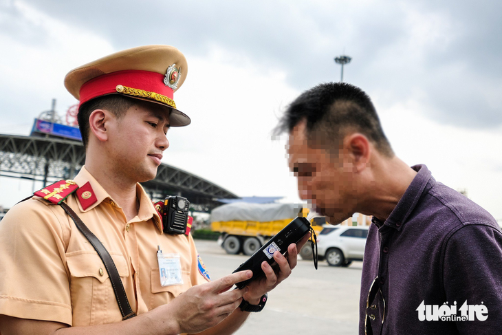 Một cán bộ cảnh sát giao thông hướng dẫn tài xế thổi nồng độ cồn trên cao tốc Pháp Vân - Cầu Giẽ - Ảnh: NAM TRẦN