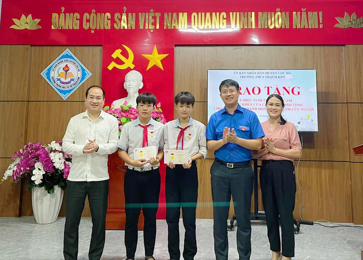 Em Sinh và Phong được trao tặng huy hiệu "Tuổi trẻ dũng cảm" vì đã cứu hai em nhỏ khỏi đuối nước - Ảnh: H.A.