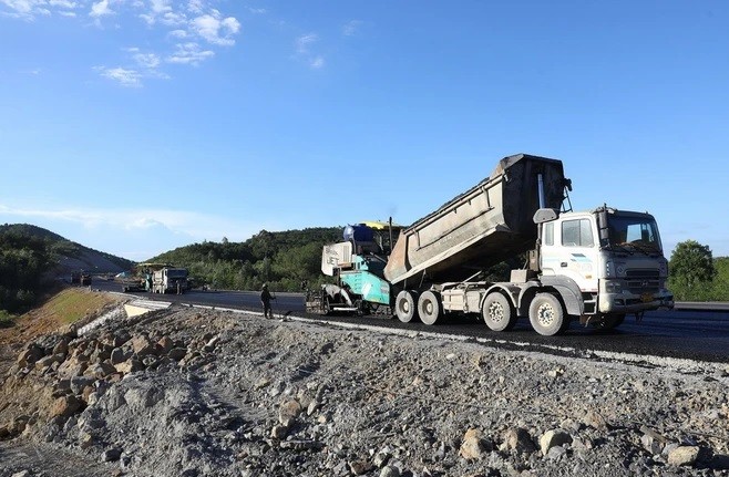 Trải thảm nhựa lớp trên cùng tại gói thầu số 2 Tuyến Cao tốc Nghi Sơn-Diễn Châu. (Ảnh: Huy Hùng/TTXVN).