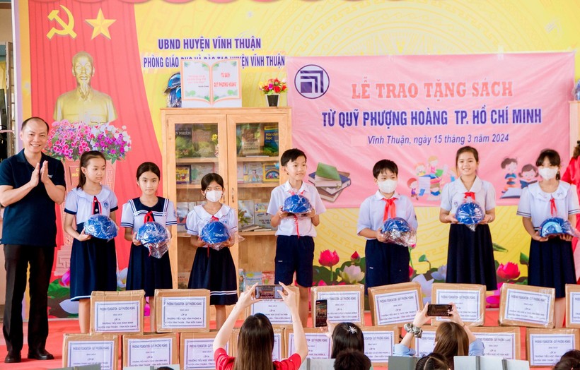 Đại diện Quỹ Phượng Hoàng TP Hồ Chí Minh trao tặng 120 nón bảo hiểm cho các em HS Trường Tiểu học thị trấn 1.