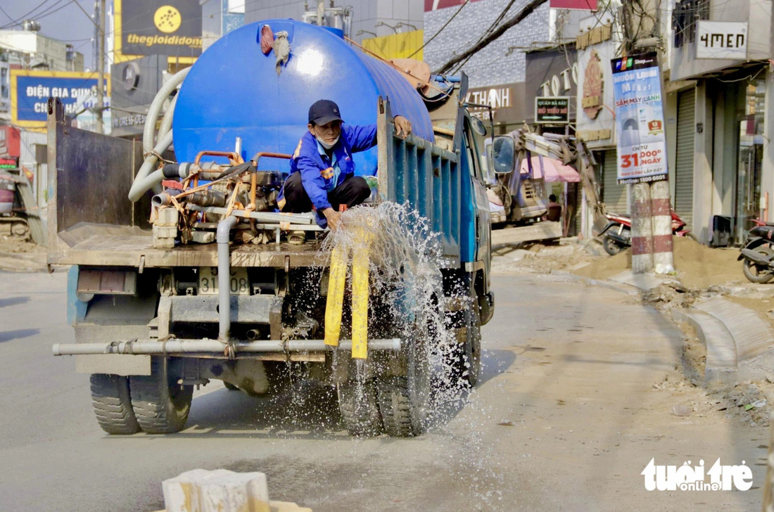 Đơn vị thi công tiến hành tưới nước bề mặt đường Võ Văn Ngân giảm tình trạng cát bụi bay - Ảnh: TIẾN QUỐC