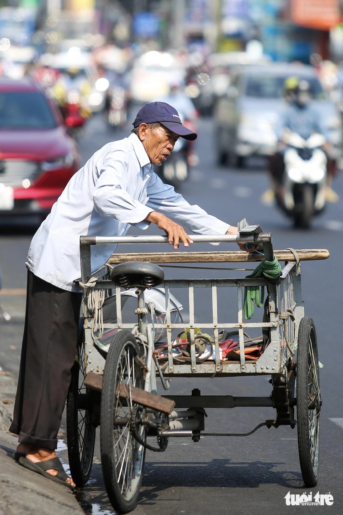 Ông Nam (65 tuổi) xếp hàng chuẩn bị đi giao cho khách lúc 11h trưa. Ảnh chụp trên đường Bạch Đằng (quận Bình Thạnh) - Ảnh: PHƯƠNG QUYÊN