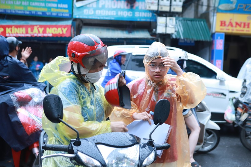 Dù có mưa nhưng phụ huynh không quên mang cho con đầy đủ các giấy tờ cần thiết như thẻ dự thi, CCCD, bút viết, bút chì, tẩy... trước khi vào phòng thi.