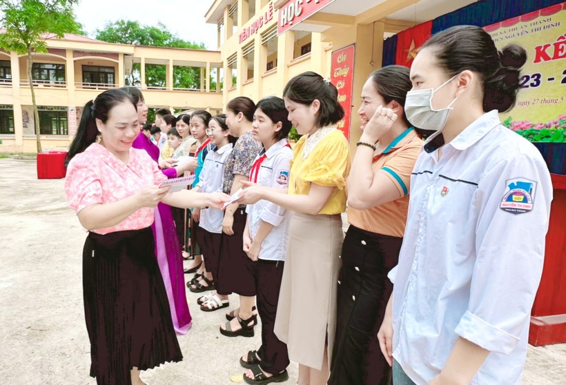 Cô giáo Nguyễn Thị Tươi (bên trái hàng đầu) trao khen thưởng cho giáo viên, học sinh nhà trường có nhiều thành tích.