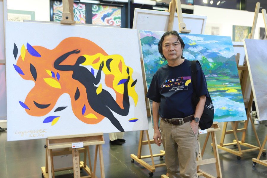 Họa sĩ Công Quốc Hà và một trong các tác phẩm tham dự triển lãm của mình. 3.jpg