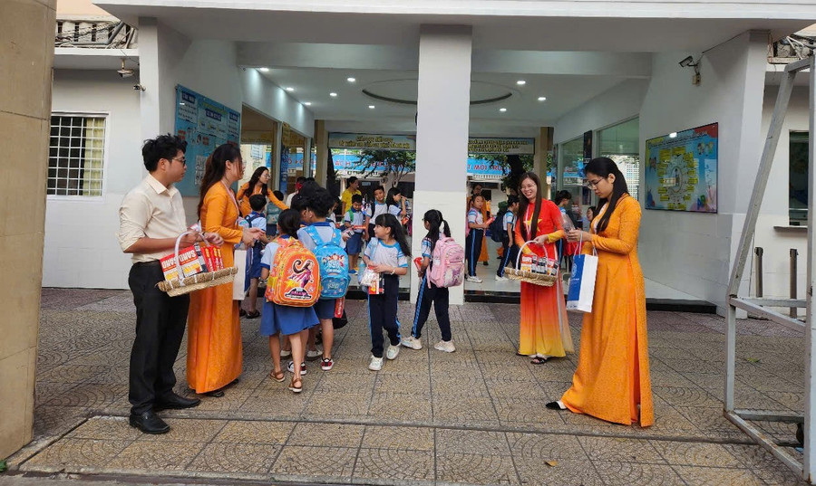 Tại cổng Trường tiểu học Trần Hưng Đạo (Quận 1), các thầy cô giáo đã chào đón các em học sinh trở lại trường với những món quà nhỏ. truong-hoc-chao-mung-95-nam-ngay-thanh-lap-dang-cong-san-viet-nam-2.jpg