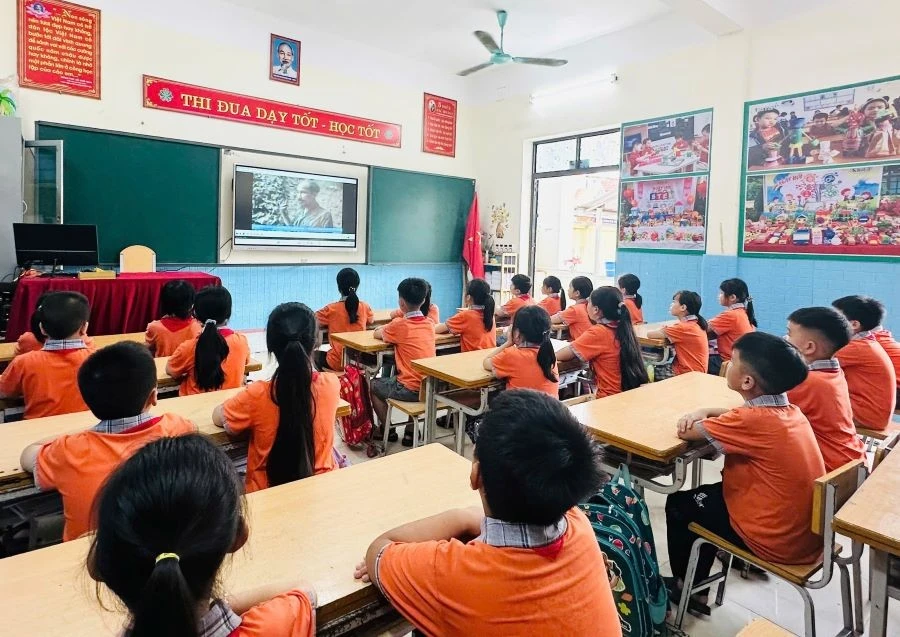 Các em học sinh lớp 3A1, trường Tiểu học Cao Xá (huyện Lâm Thao) xem video, tư liệu tìm hiểu về thân thế, sự nghiệp của Bác Hồ kính yêu.