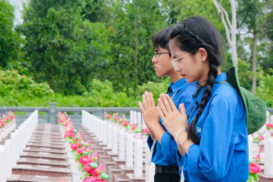 Sinh viên EPU thắp nén hương tưởng niệm và tri ân tại Nghĩa trang Liệt sĩ Trường Sơn. Ảnh: Châu Linh.