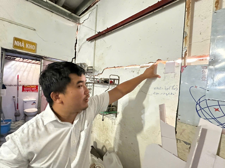Ông Nguyễn Anh Sơn chỉ tay vào những vết nứt tường do công trình xây dựng kế bên gây ra. (Ảnh: Hà An)