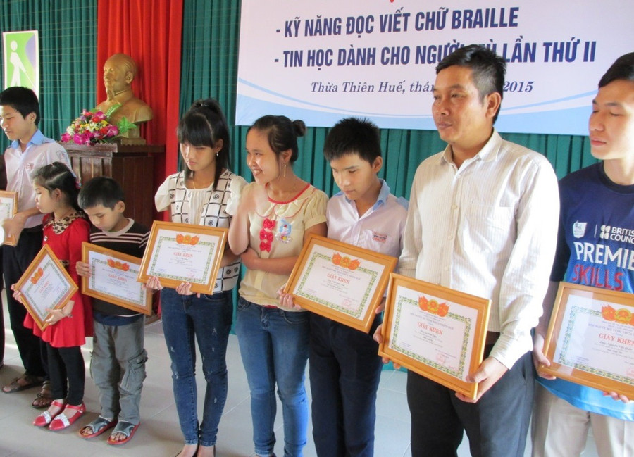 Các người khiếm thị TP Huế nhận bằng khen ở lễ tổng kết lớp học kỹ năng đọc viết chữ Braille.