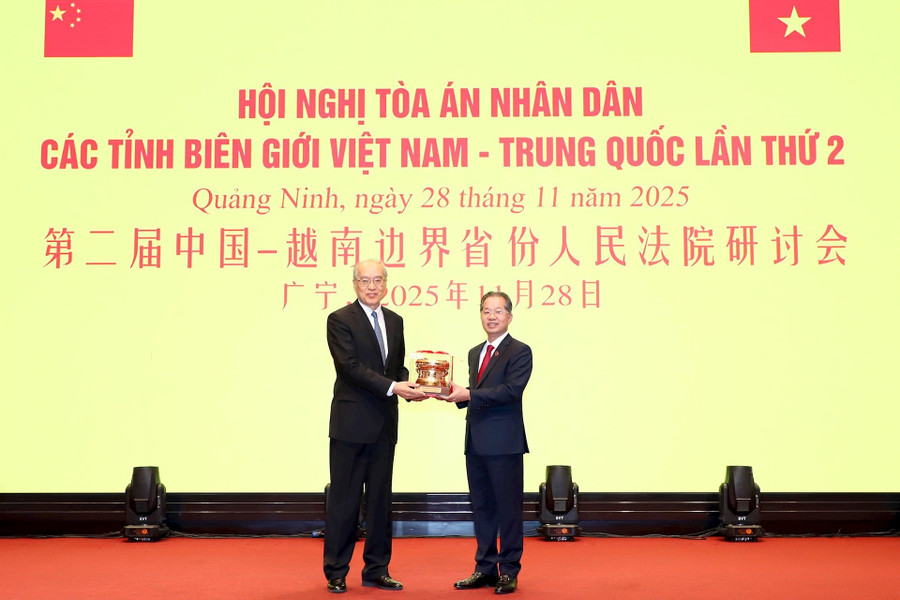 Chánh án Nguyễn Văn Quảng trao quà kỷ niệm tặng Chánh án Trương Quân.