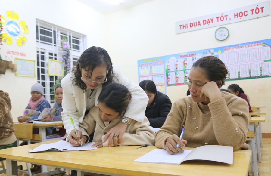 Cô Trần Thị Châu giúp học viết viết từng nét chữ.