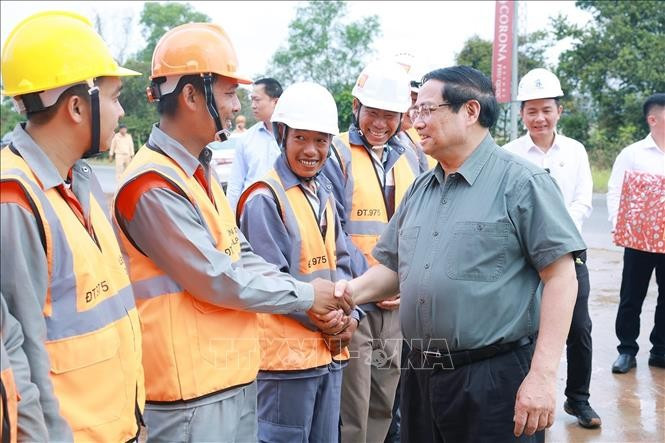 Thủ tướng Phạm Minh Chính với công nhân thi công dự án Đường tỉnh ĐT.975 (đoạn từ ĐT 973 - Cảng hàng không Phú Quốc). Ảnh: Dương Giang/TTXVN